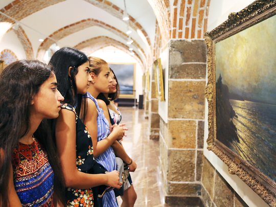 Young girls looking at a painting