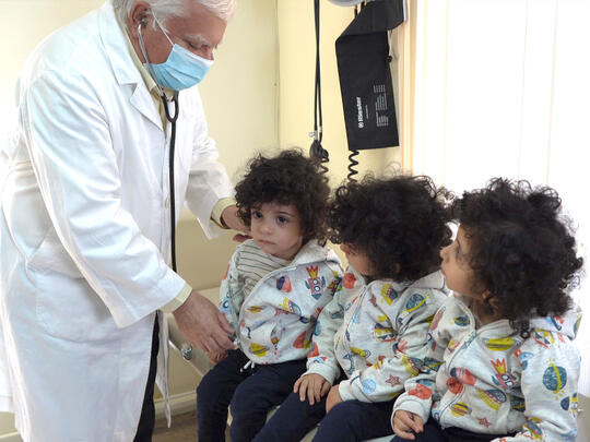 Dr. Darakjian checking Syrian Armenian Triplet kids